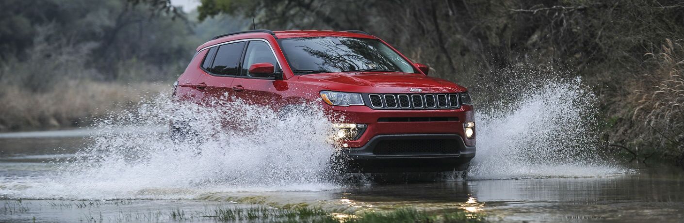 A photo of a 2019 Jeep Compass crossing a river.