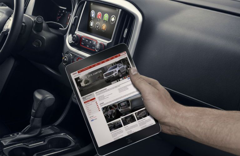 A photo of someone connecting a tablet computer to the Wi-Fi in the 2018 Canyon.