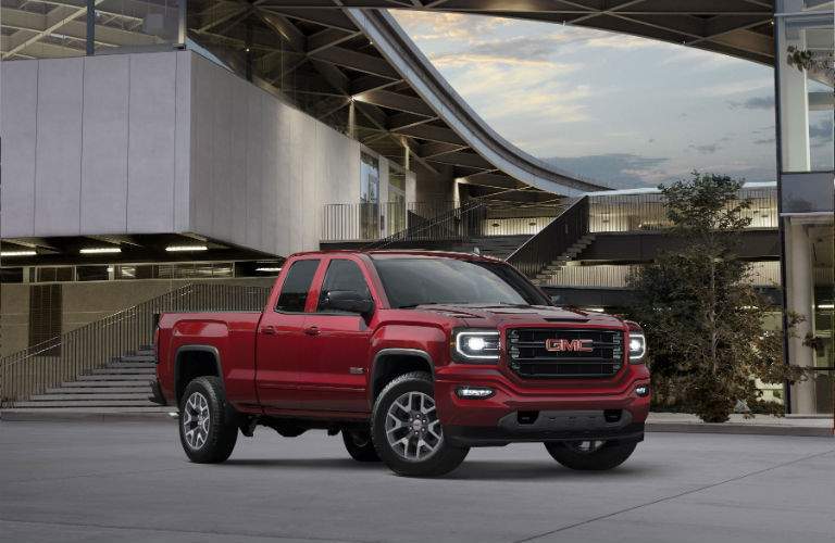 A front right quarter view of the 2018 GMC Sierra in front of a building