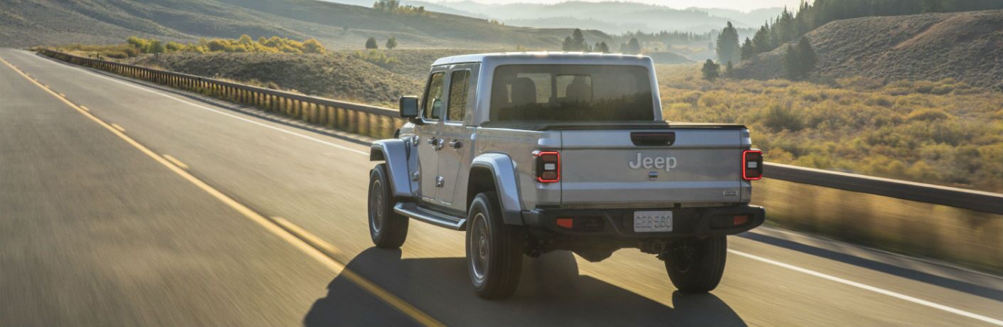 A rear left quarter photo of the 2020 Jeep Gladiator on the road.