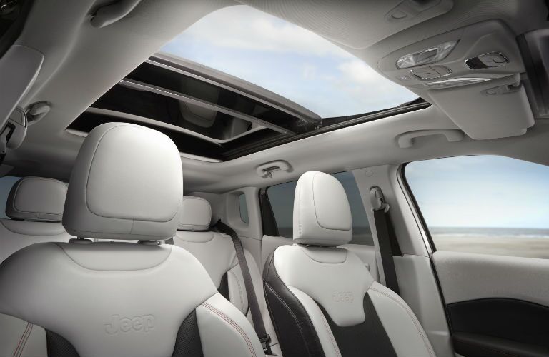 A photo of the front seats and sunroof in the 2019 Jeep Compass.