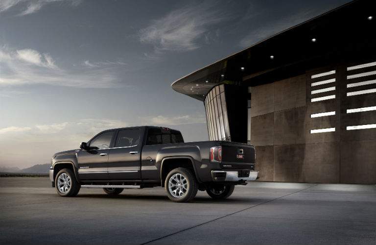 A left profile view of a black 2018 GMC Sierra near a stadium