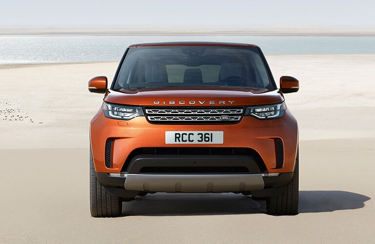 front view of orange land rover discovery parked on beach