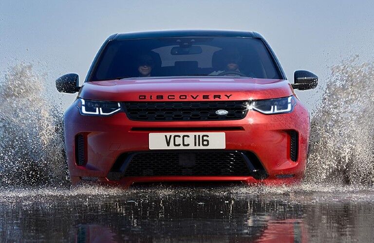 Red 2020 Land Rover Discovery Sport driving through a stream