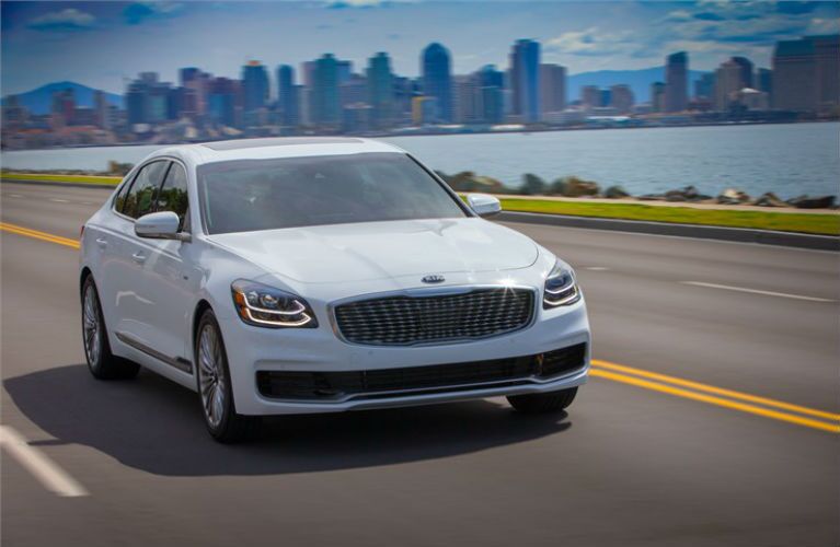 2019 Kia K900 driving away from a city