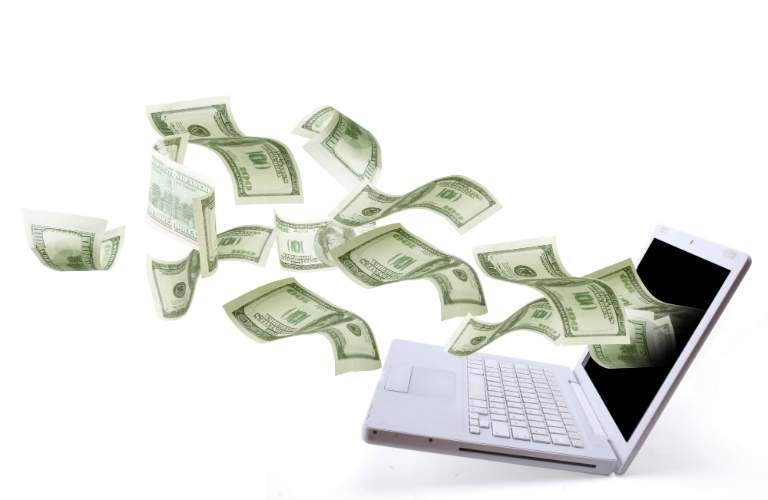 money flying out of a computer screen
