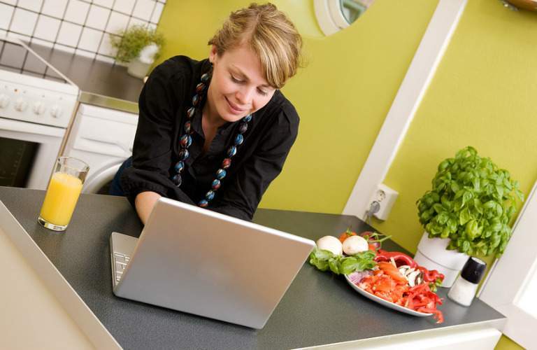woman in kitchen looking at computer