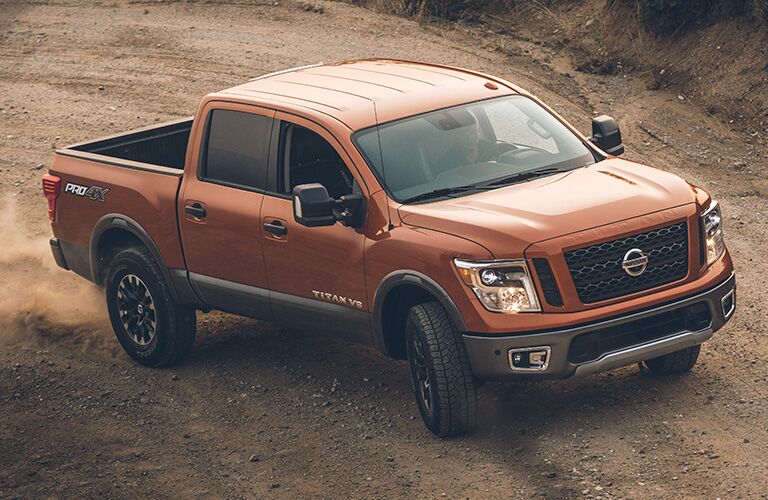 Brown 2019 Nissan Titan, raised view looking down at the side/front. It's driving through a landscape of dirt.