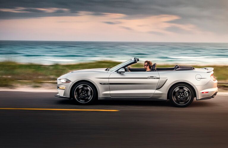 man driving the 2019 Ford Mustang California Special with top down near the ocean