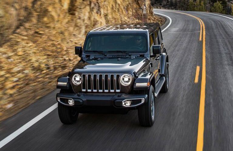 front view of 2019 Jeep Wrangler driving down highway