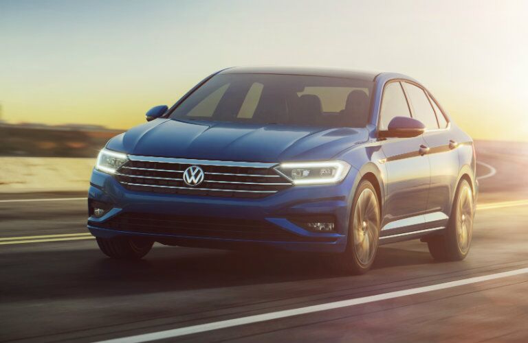 2019 VW Jetta rounding a highway curve at sunset