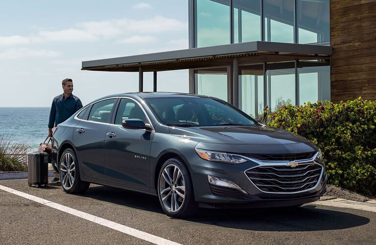 man loading trunk of 2020 Chevy Malibu