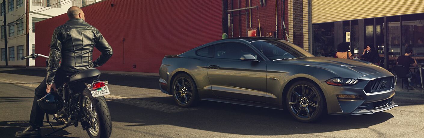 man on motorcycle admiring 2020 Ford Mustang
