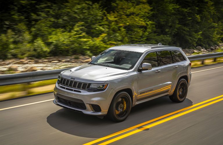 A front left quarter photo of a Jeep vehicle on the road.