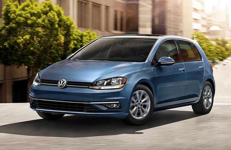 A photo of a VW hatchback in motion on the street.