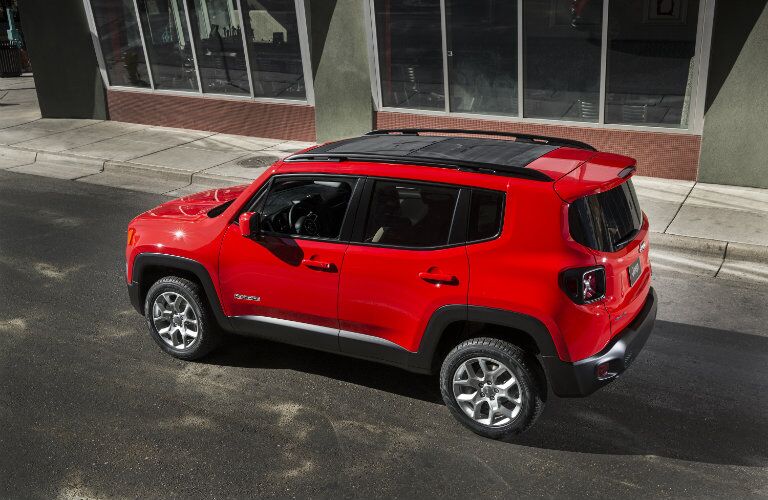 side and rear view of red 2018 jeep renegade on empty street