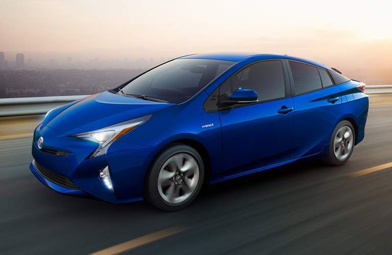 Blue 2018 Toyota Prius Front on Highway with City in Background