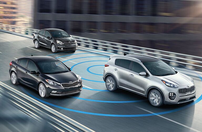 silver 2018 kia sportage using blind spot detection with two cars behind it