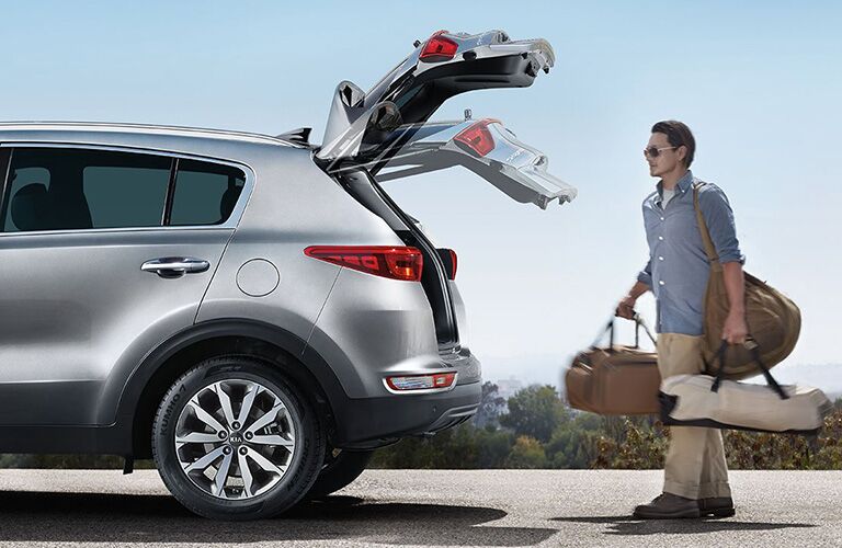 man carrying bags using the motion activated liftgate of 2018 kia sportage