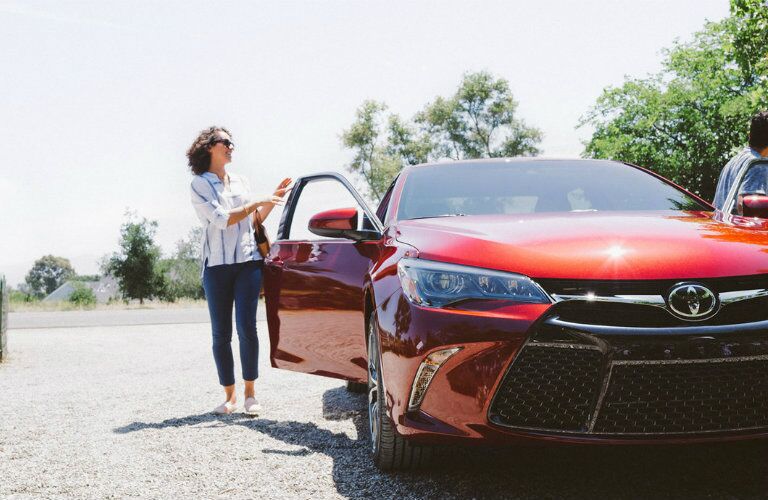 front view of red used Toyota Camry, woman getting in passenger side