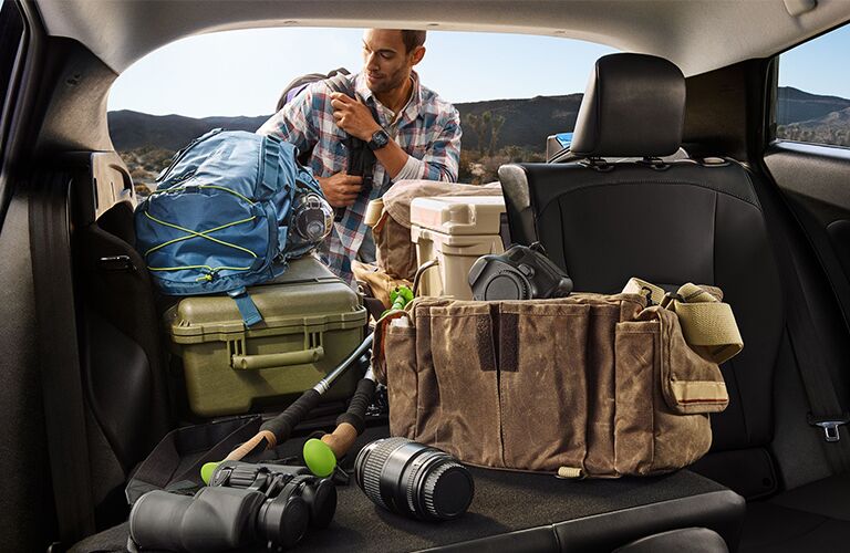 A man getting gear from the cargo area of a 2020 Toyota Prius