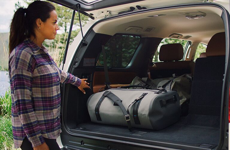 A woman standing next to the cargo area of a 2020 Toyota Sequoia