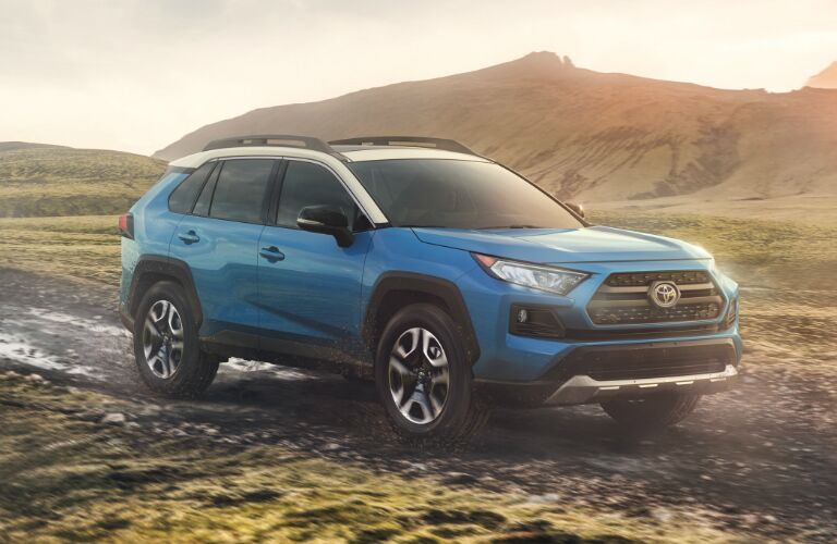 Blue 2020 Toyota RAV4 driving on a muddy road