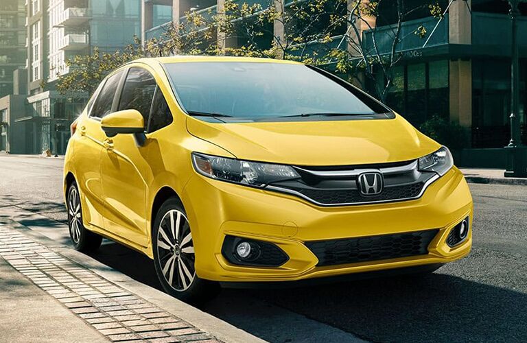 front view of yellow honda fit parked on side of road