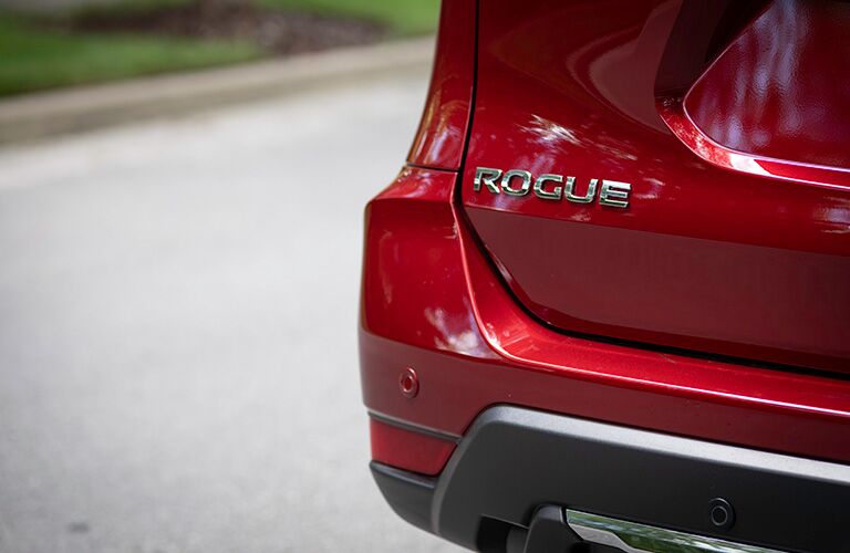 rogue badge on back of red nissan rogue