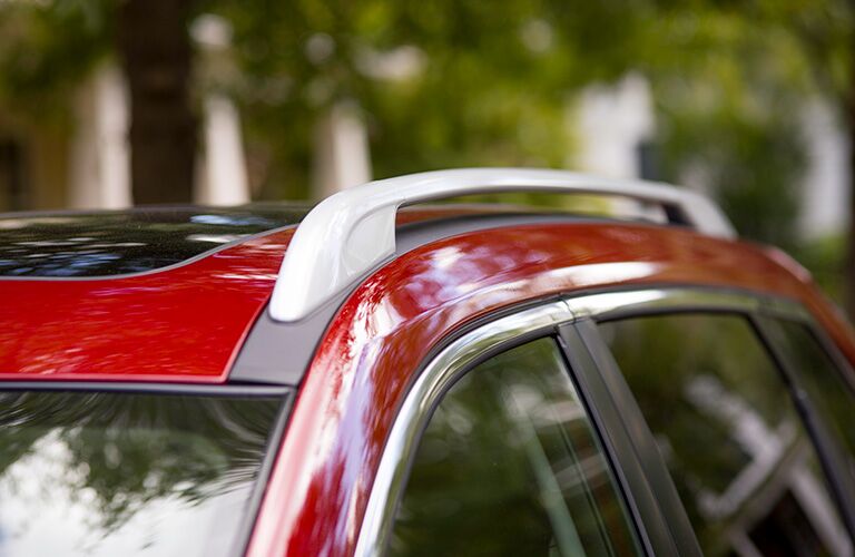 white roofrails on top of red nissan rogue
