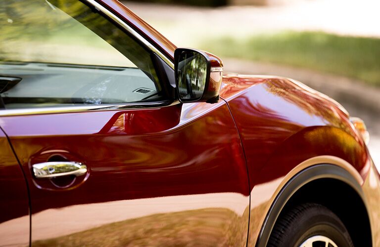 right sideview mirror of red nissan rogue