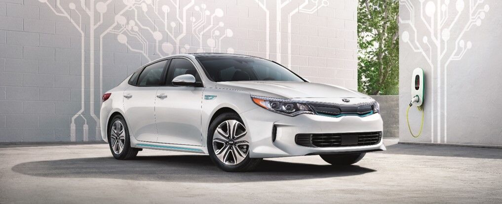 Kia Optima Plug-In Hybrid next to an EV charging station