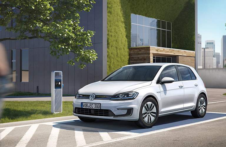White Volkswagen e-Golf parked next to charging station