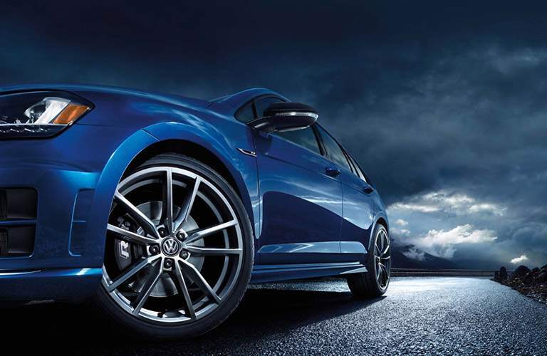Blue Volkswagen Golf R parked on street with cloud cover overhead