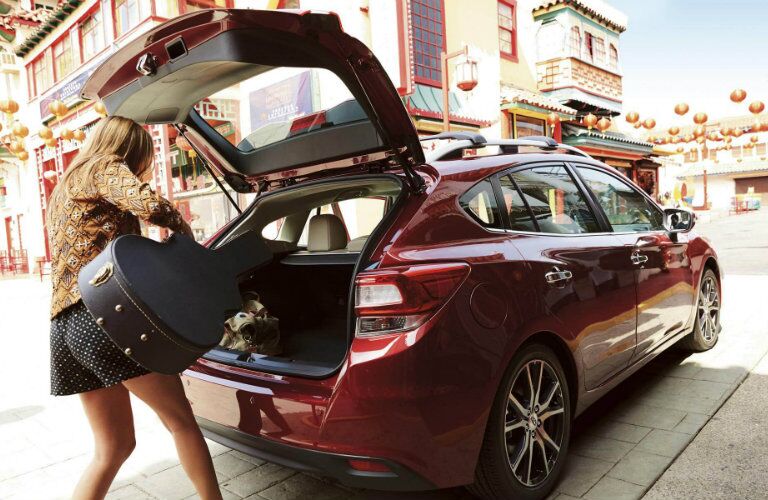 Woman loading a guitar in the 2018 Subaru Impreza