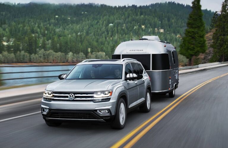 2018 Volkswagen Atlas driving down the highway with a trailer in tow