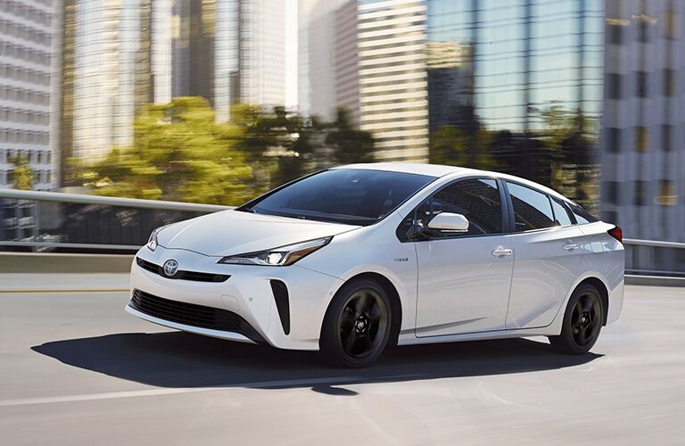 2020 Toyota Prius driving on the highway with a city in the background