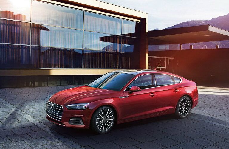 red Audi A5 parked by modern building