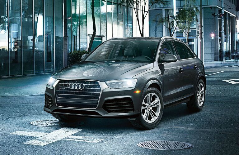 gray Audi Q3 parked by window-lined building