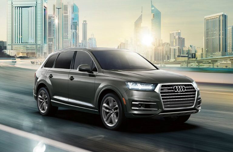 gray Audi Q7 driving down city highway