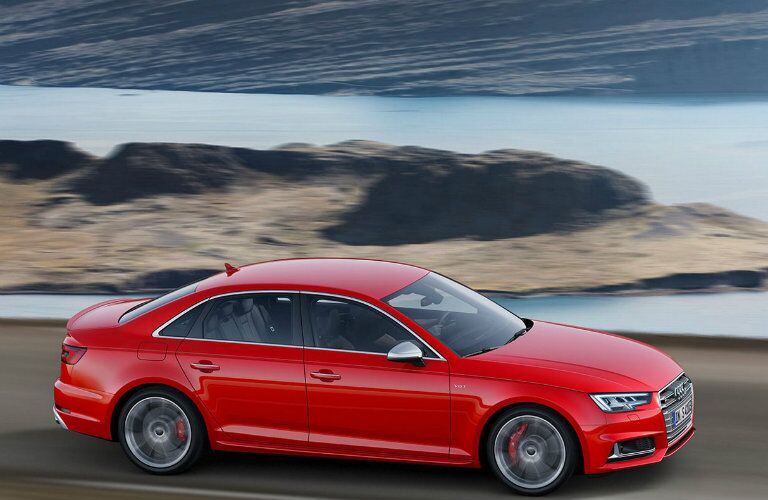 red Audi S4 driving along water-side highway