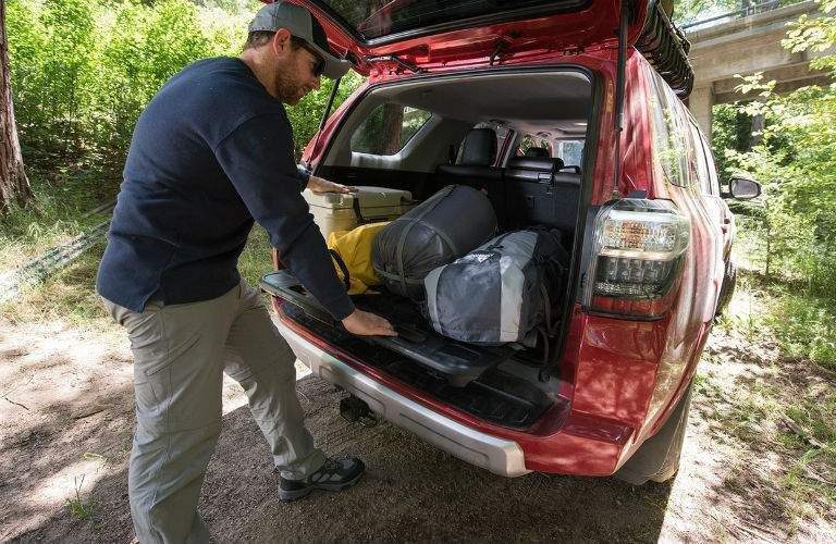 Man inspecting rear cargo area of 2018 Toyota 4Runner