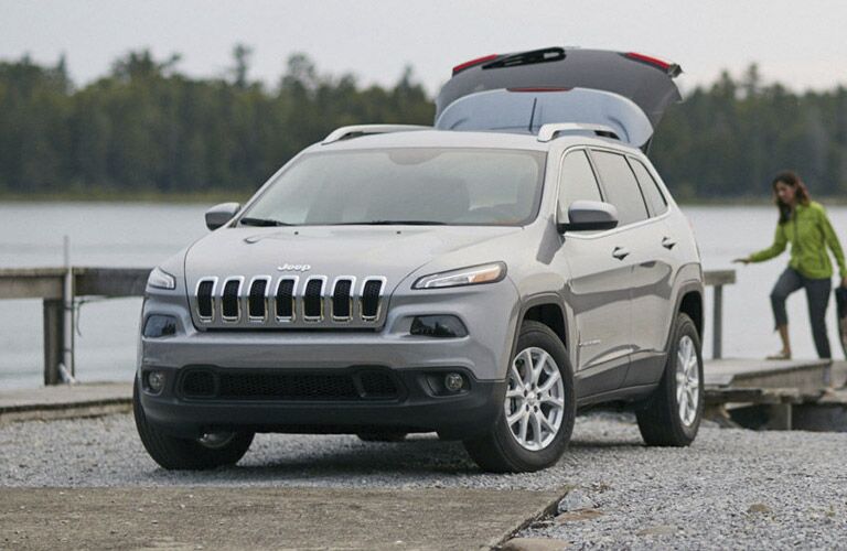 2016 Jeep Cherokee in grey parked near a lake with the rear hatchback open