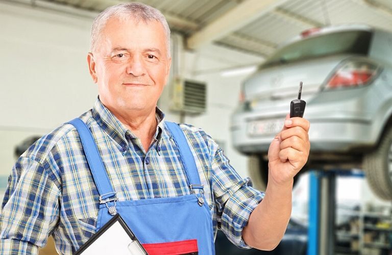 Mechanic Holding a Car Key in a Garage