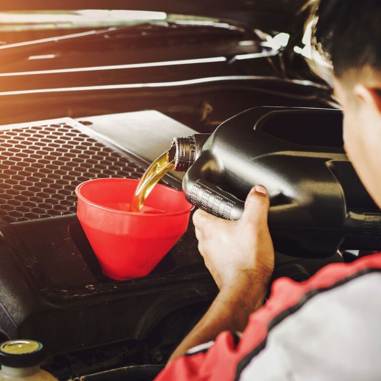 Tech draining oil from a car