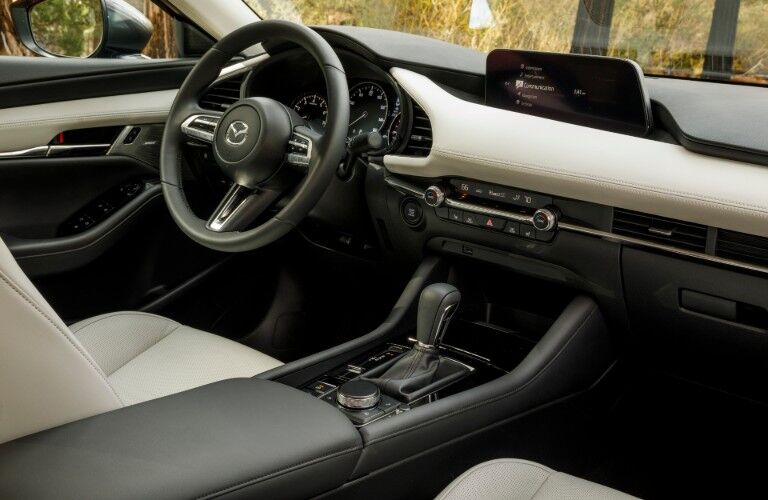 2020 Mazda3 sedan interior shot of front seating upholstery, transmission, steering wheel, and dashboard design and setup
