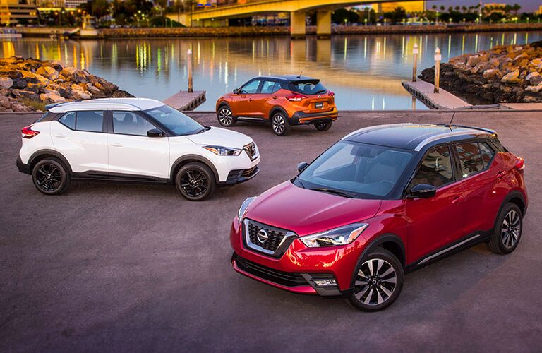 assortment of nissan kicks crossovers in a variety of red white and orange colors