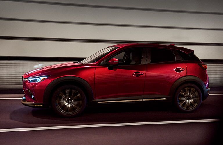 2019 Mazda CX-3 exterior side shot red driving through a paneled tunnel