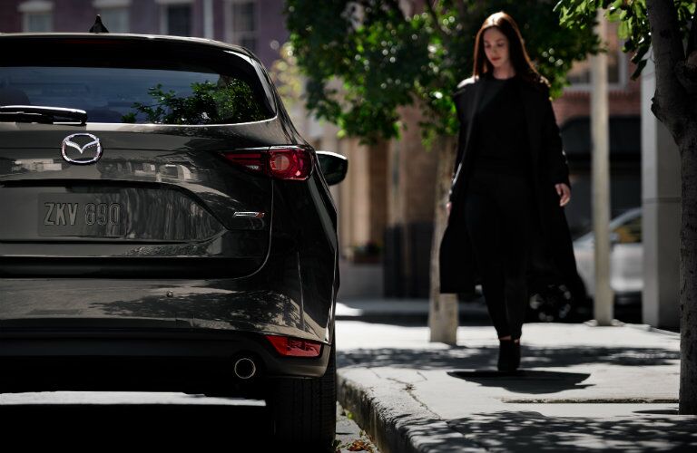 2019 Mazda CX-5 Signature SKYACTIV-D exterior rear shot of back bumper, trunk, and taillights as a woman approaches the passenger side door