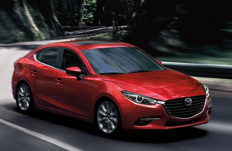 red mazda3 driving on road